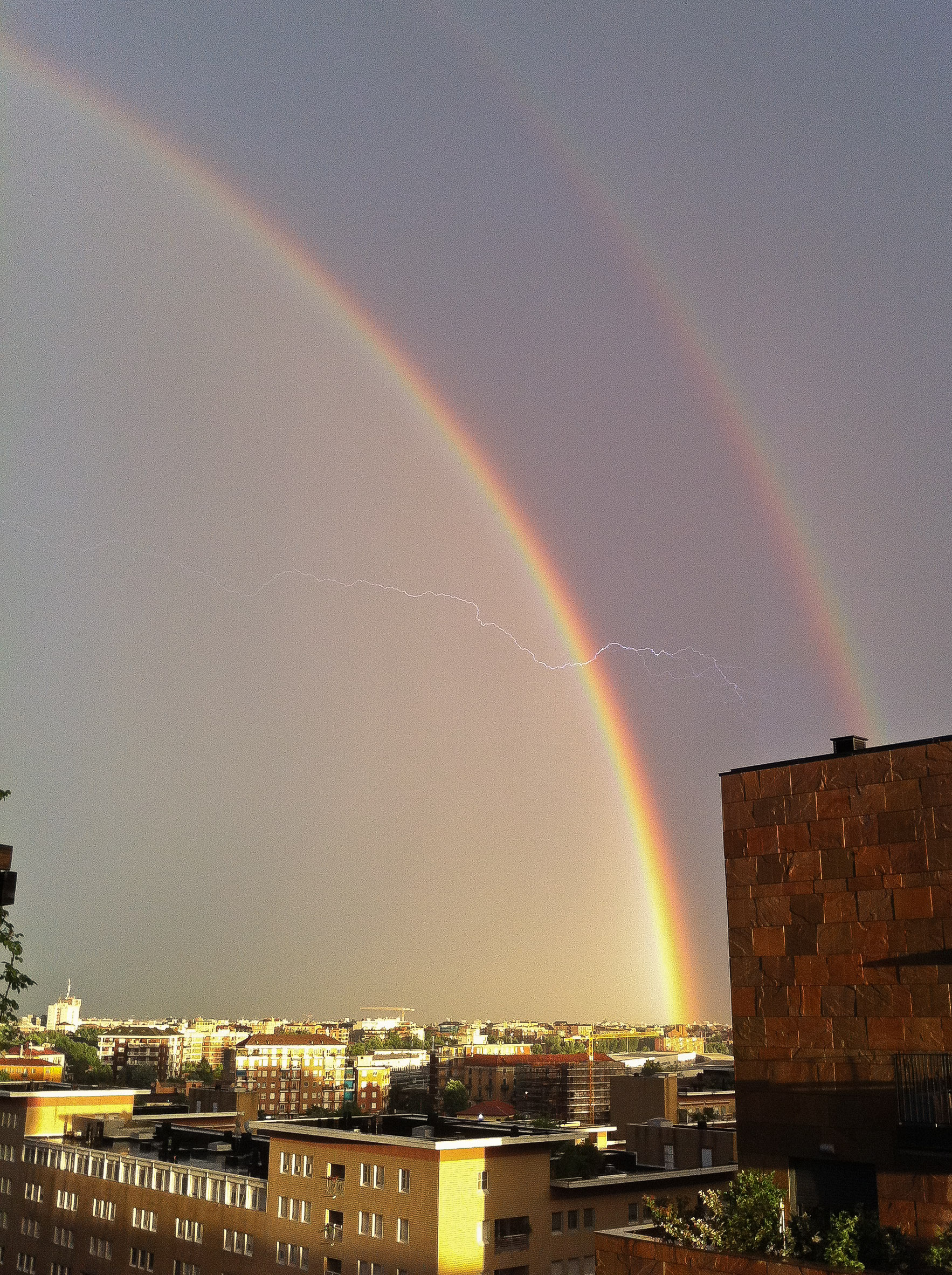 Doppio arcobaleno con fulmine a Milano...