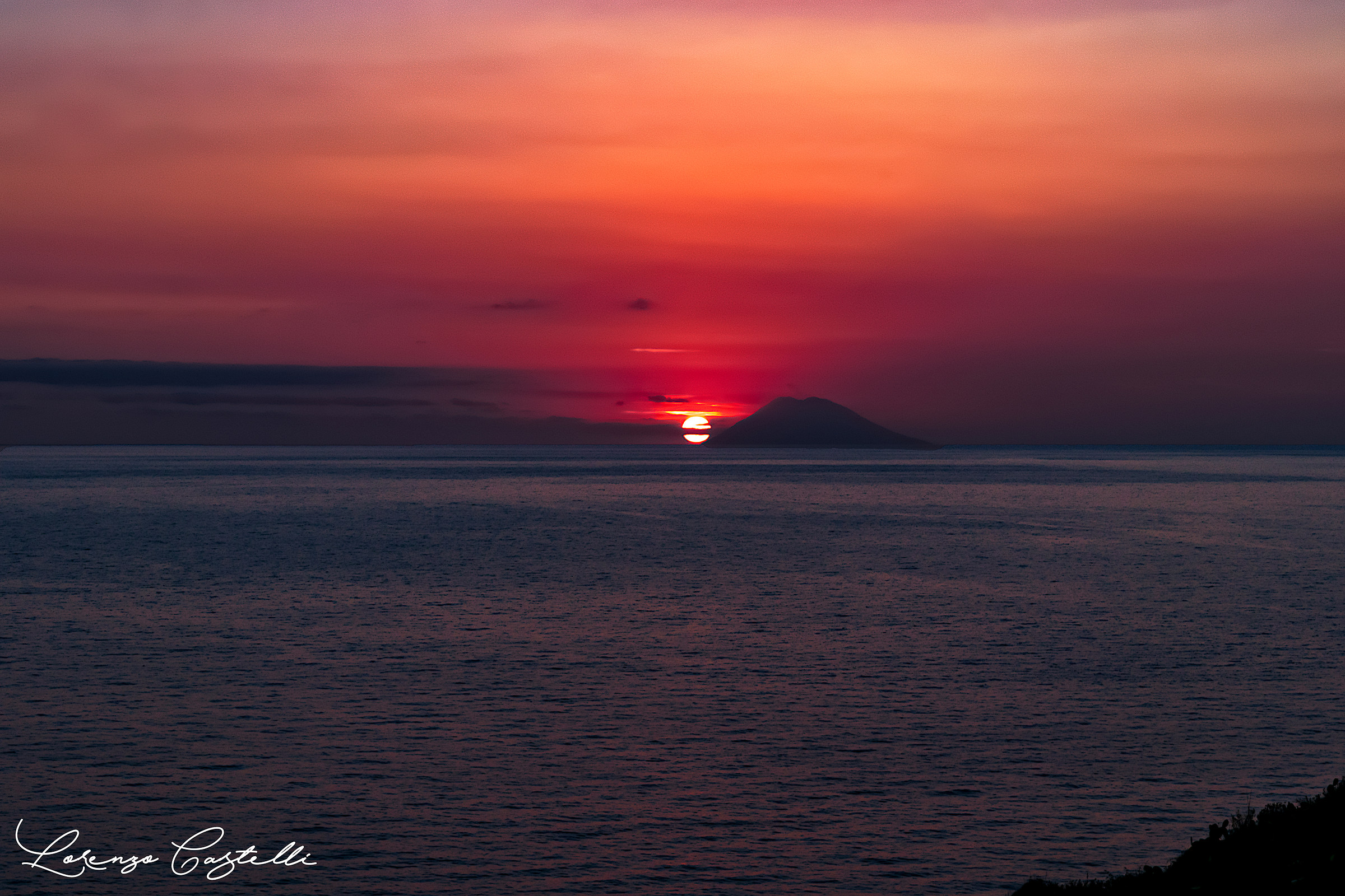 The sun is hidden behind Stromboli. The moment in cu...